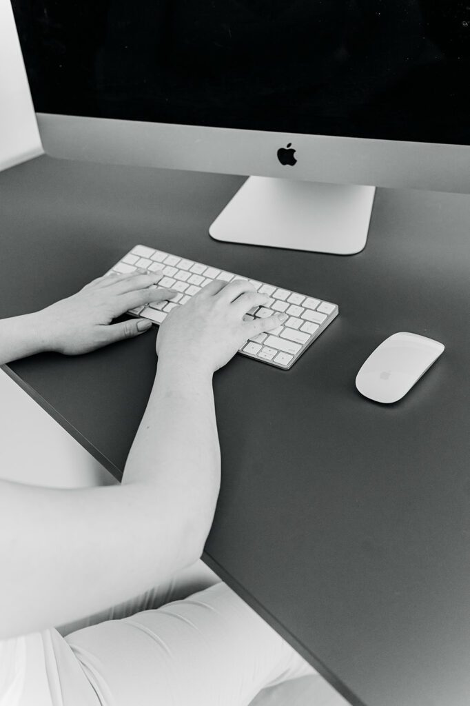 Black and White Photo of Woman doing web design on iMac