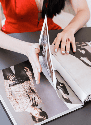Photo of woman turning page of fashion book